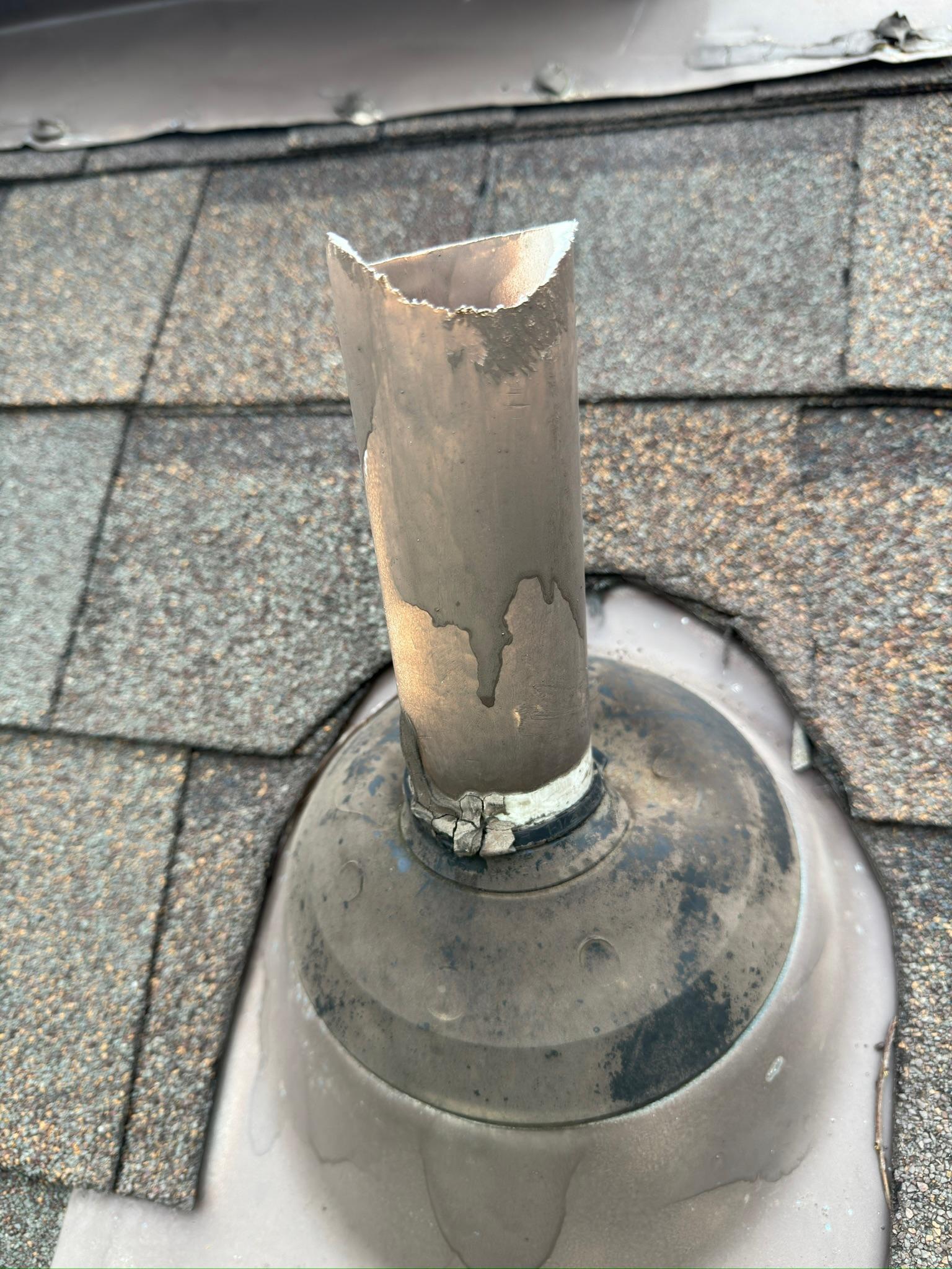 Damaged pipe extending through a roof flashing boot