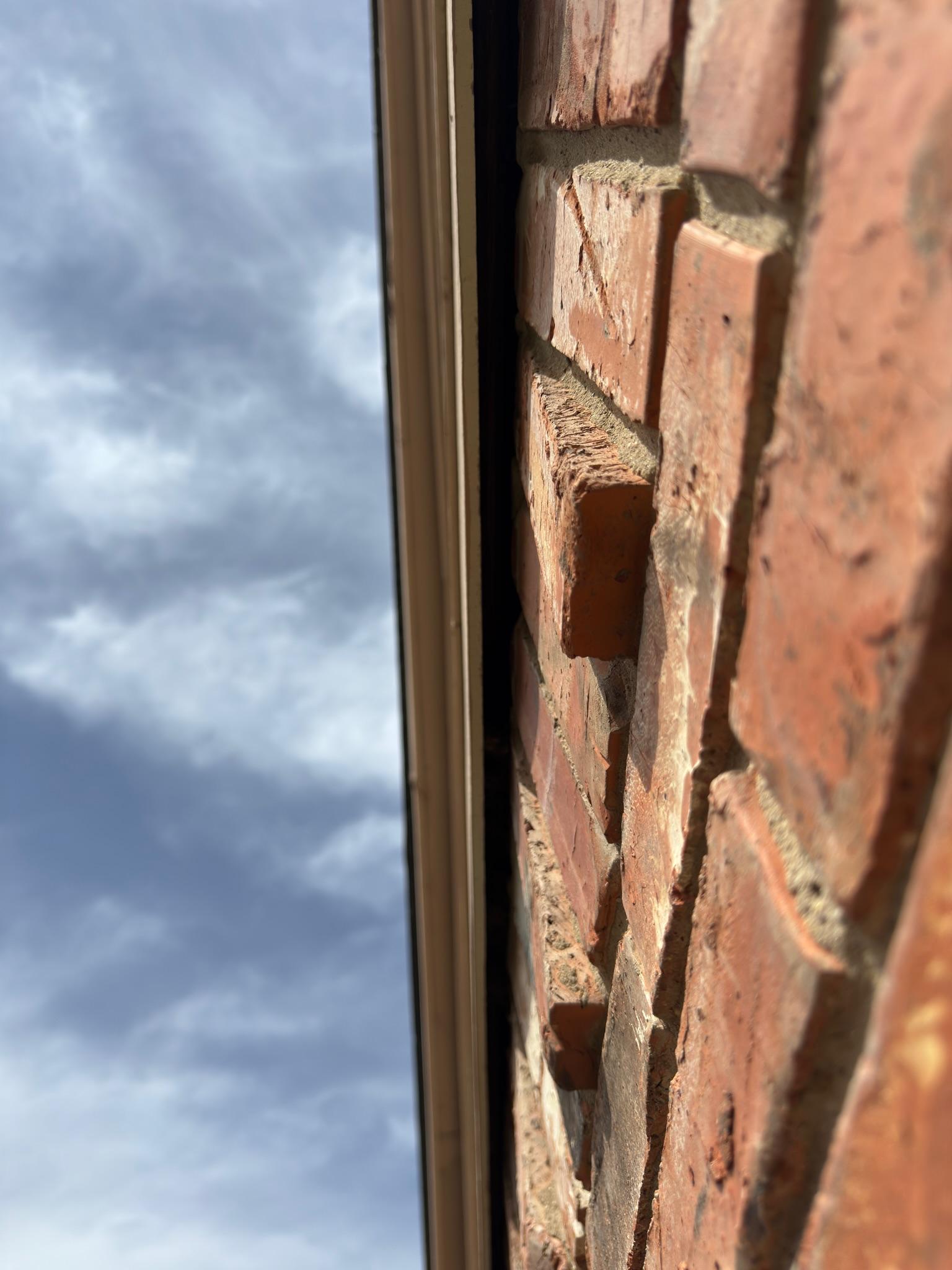 Exposed gap between wooden roof trim and brickwork