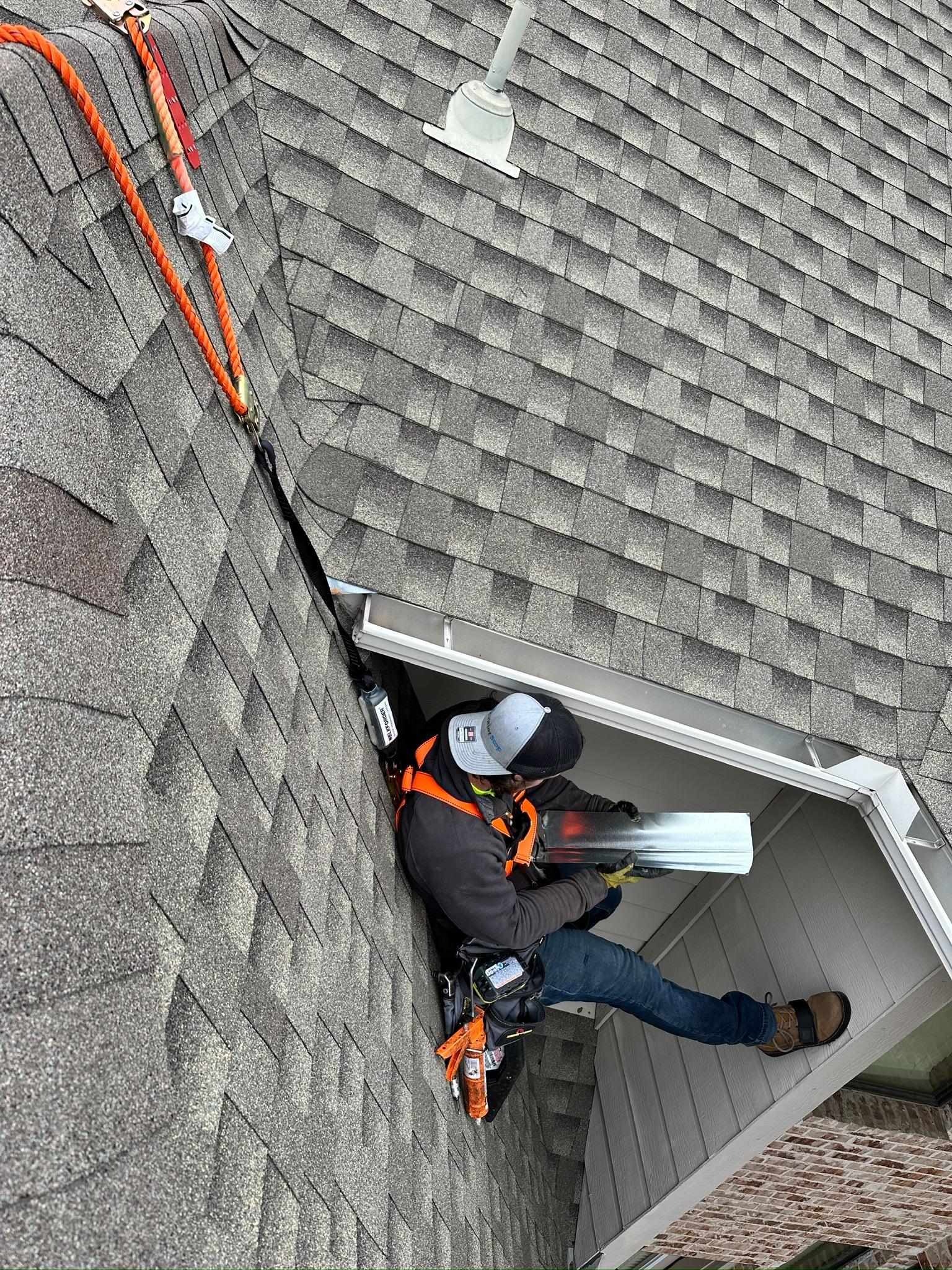 Worker using a ladder and materials at a roof edge