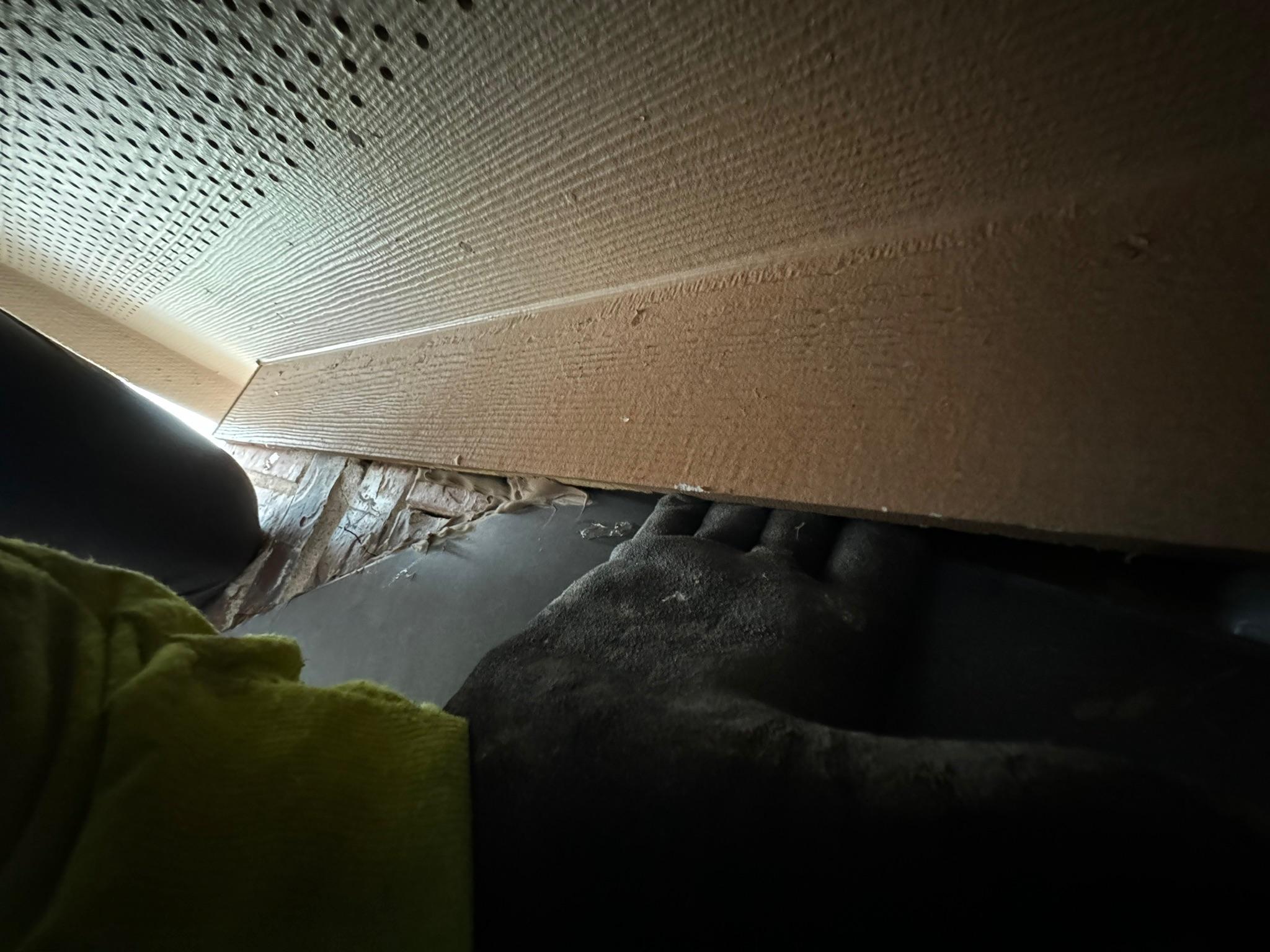 Close-up of soffit panels and trim being inspected beneath an eave