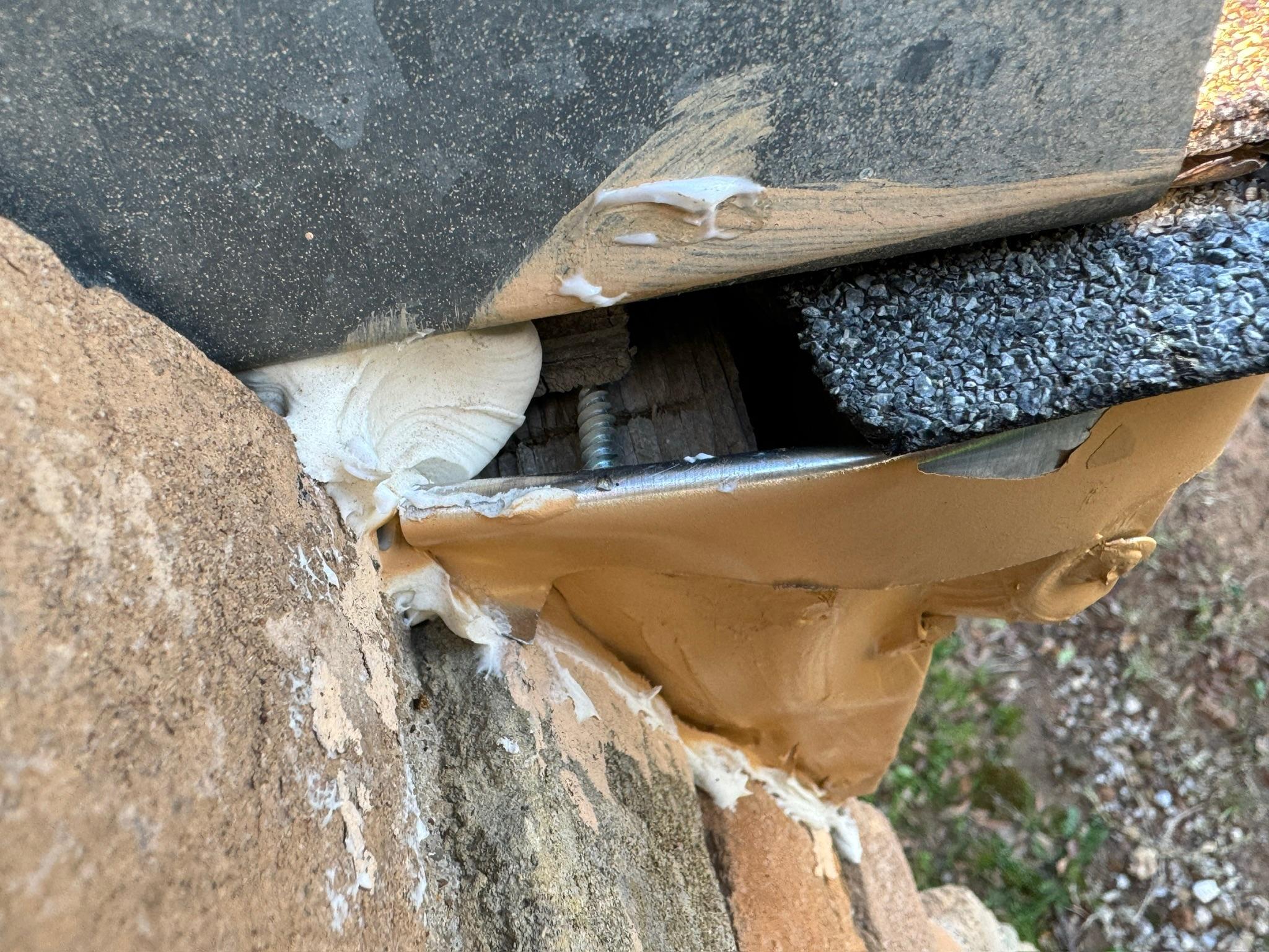 Lifted roofing and exposed materials at the edge of a roof