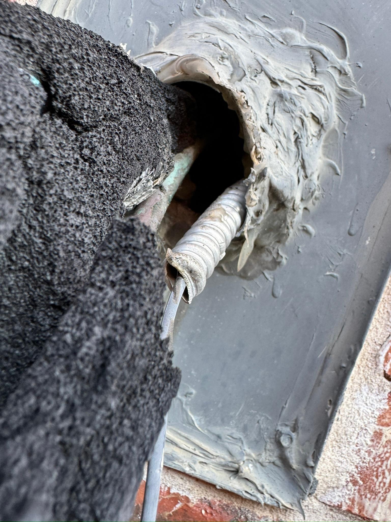 Torn flashing boot around a pipe passing through roof shingles
